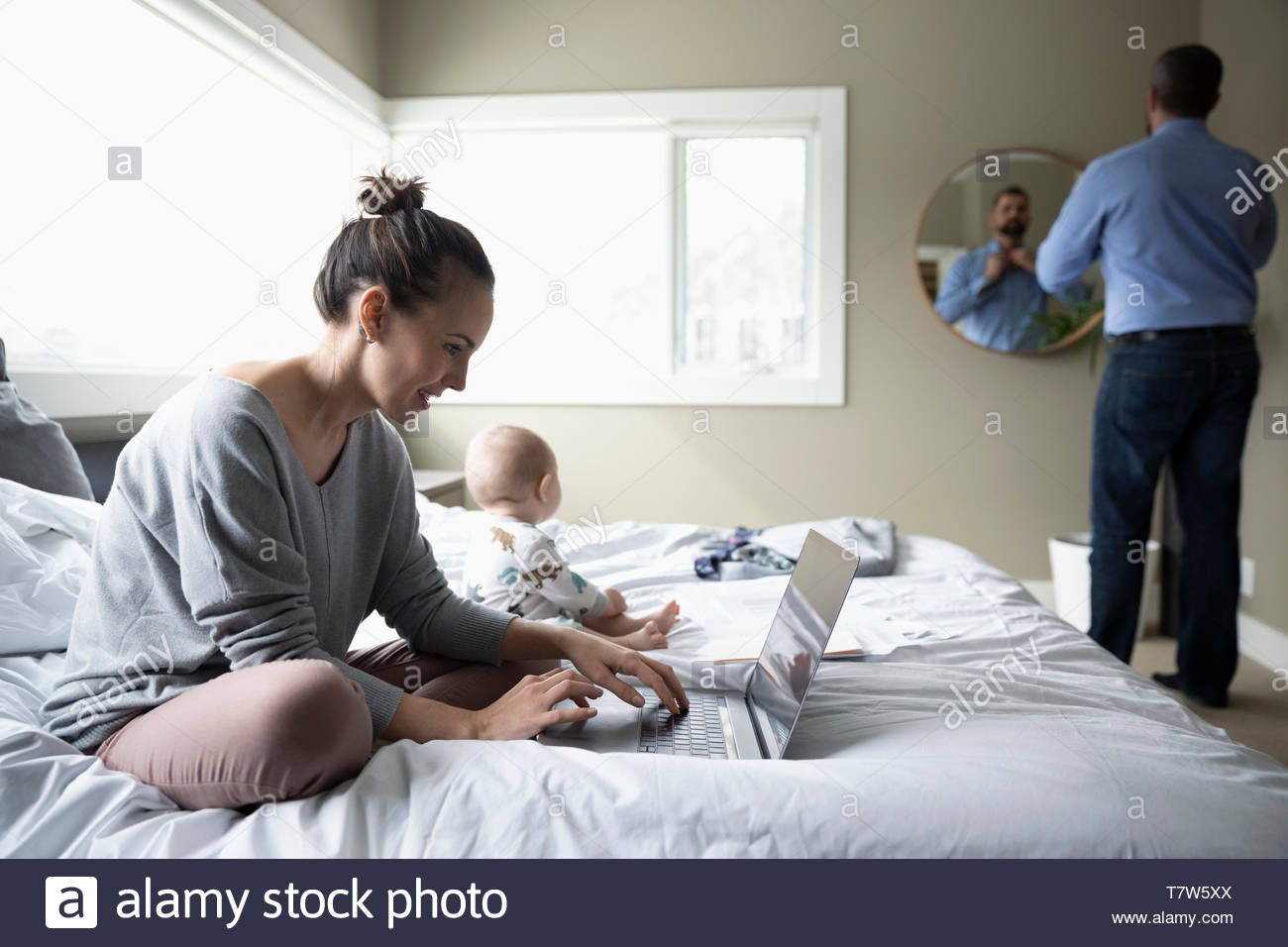 Couple with baby working from home and getting ready for work Stock Photo