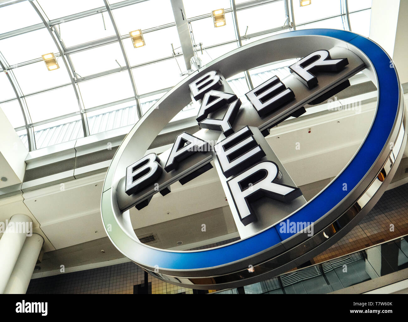Frankfurt, Germany - Apr 29, 2019: Large Bayer German multinational pharmaceutical and life sciences company logotype hanged and rotation in Terminal 1 in Frankfurt International Airport Stock Photo