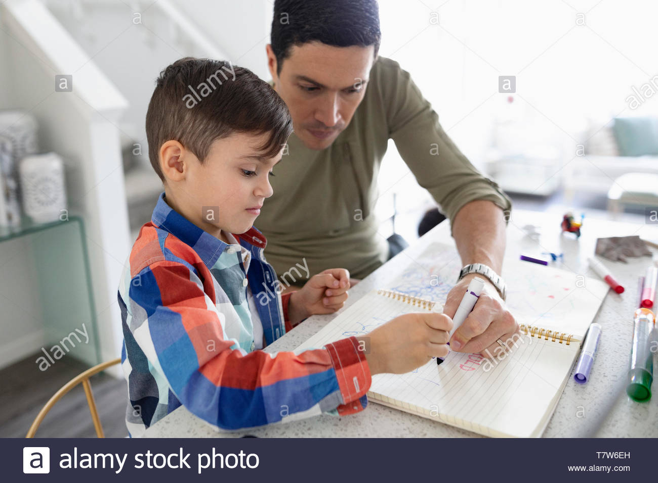 Father and son coloring in notebook Stock Photo