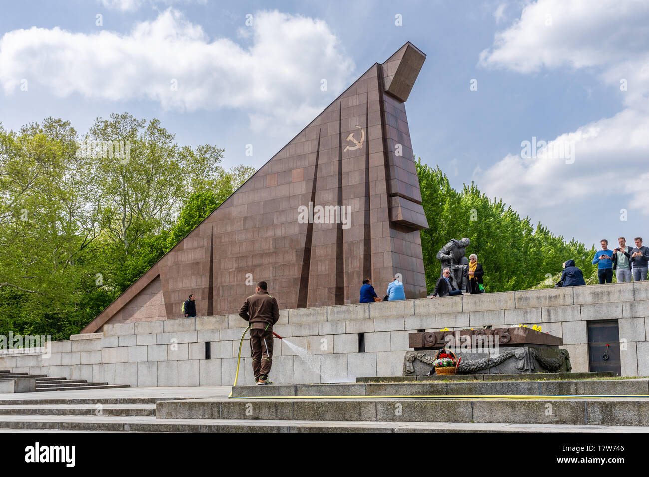 Statue of a kneeling  Soviet soldier in front of a stylized Soviet flag built from red granite at the Soviet War Memorial in Treptow, Berlin, Germany Stock Photo