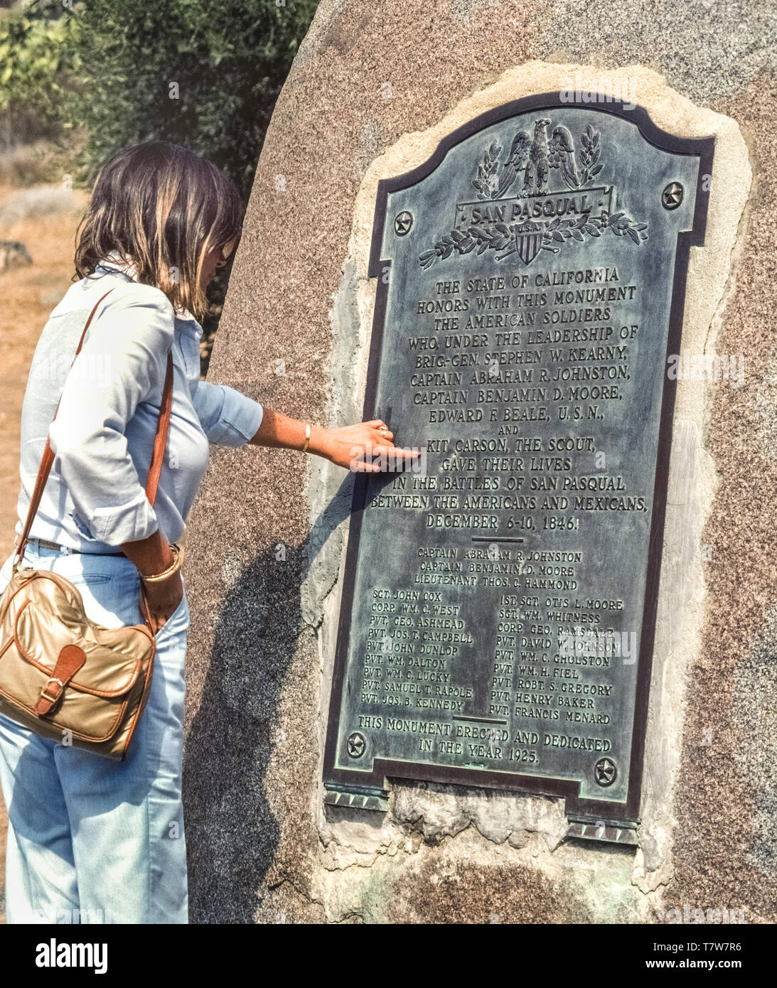 The 21 American military men who died in the bloodiest battle fought in California during the U.S.-Mexican War are honored with this bronze plaque at the 1846 battle site that is now the San Pasquel Battlefield State Park in San Diego County, USA.  A female visitor points to the name of Kit Carson, a legend of the Old West, who served as scout for the American soldiers. The U.S. troops were trying to take control of California from the Mexicans, known as Californios, who were people of Hispanic descent living in California after Mexico’s War of Independence from Spain between 1810-1821. Stock Photo