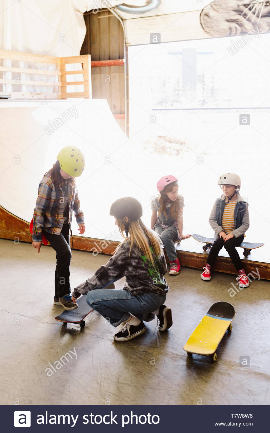 Kids learning to skateboard at indoor skate park Stock Photo