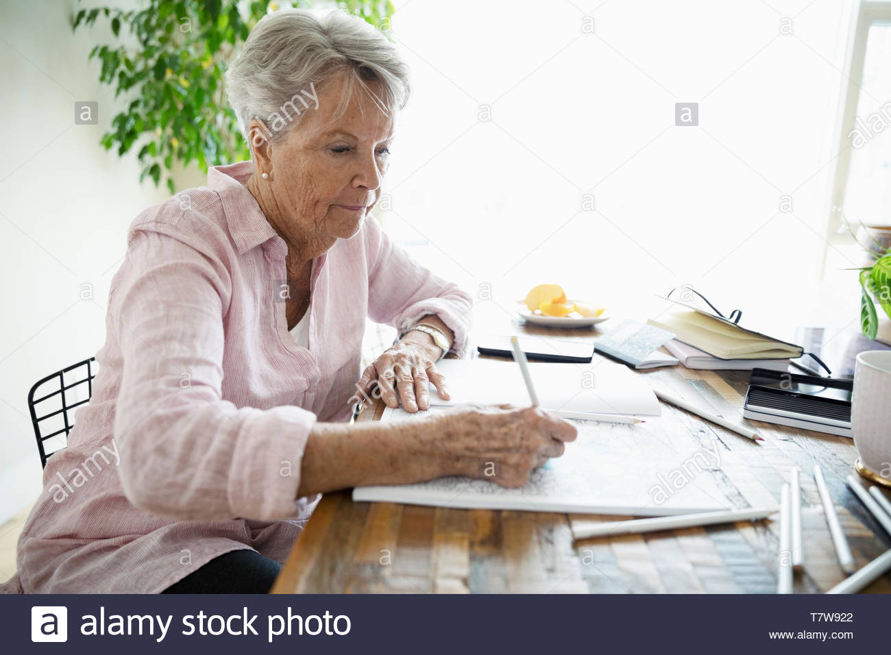Senior woman coloring in coloring book Stock Photo