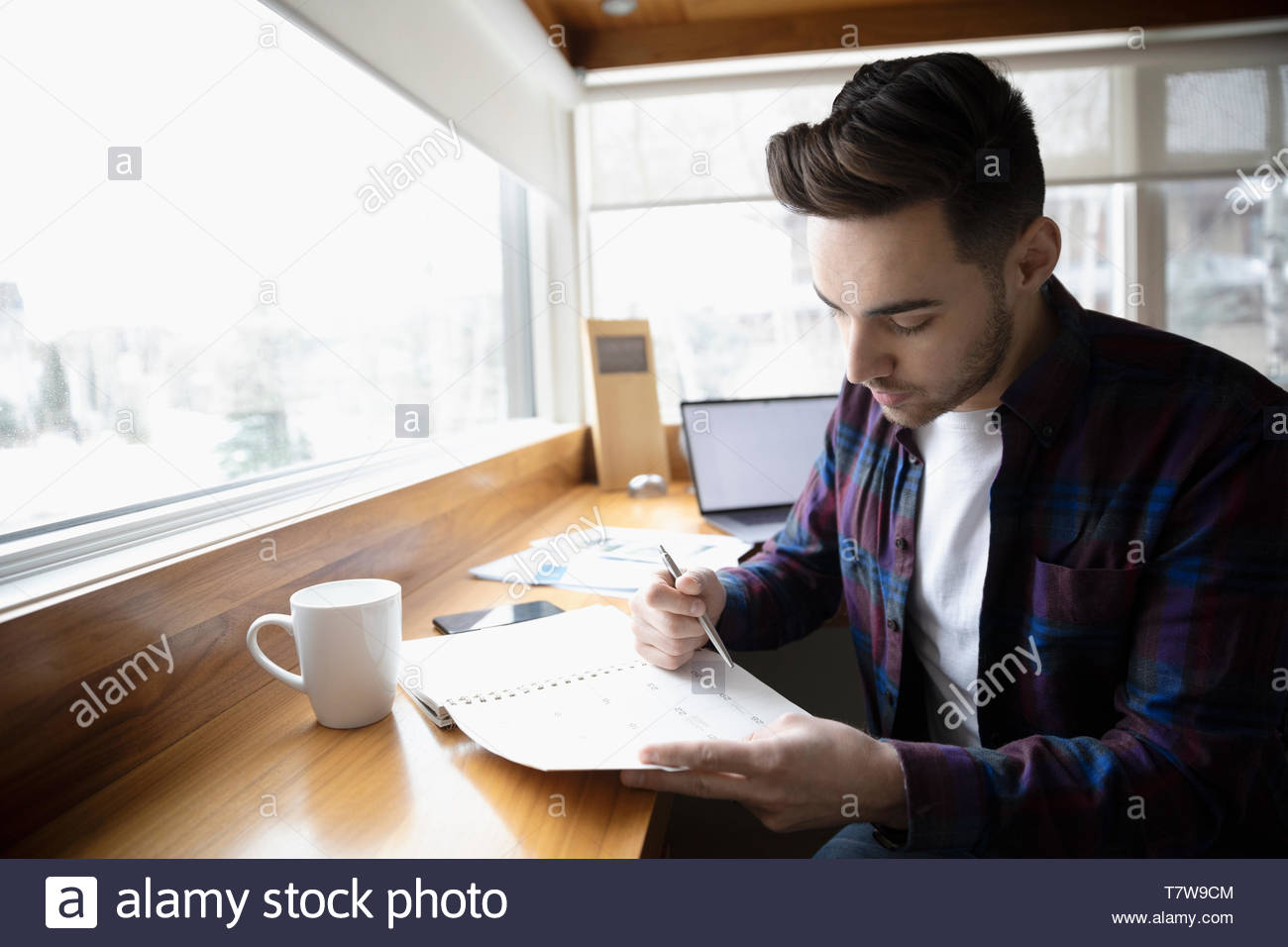 Focused young man working in home office, checking schedule calendar Stock Photo