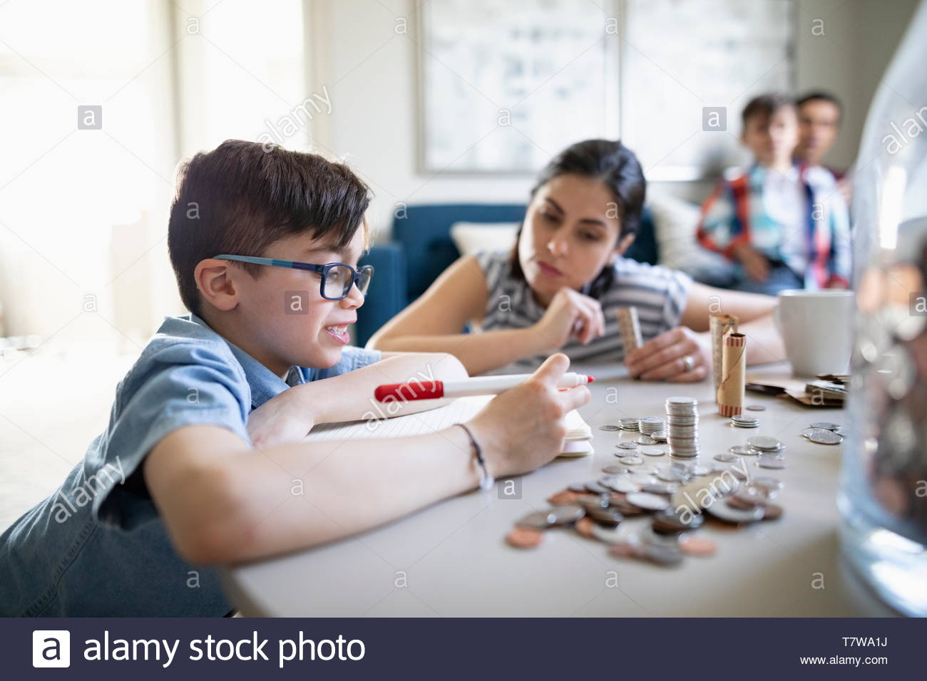 Mother watching son counting allowance money Stock Photo