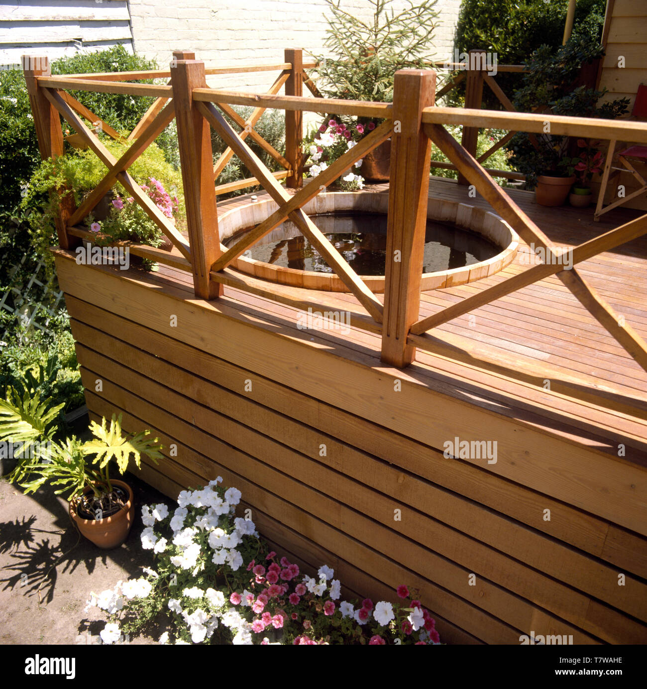 Petunias In Pots Below Raised Decking With A Circular Hot Tub In An Urban Garden Stock Photo Alamy