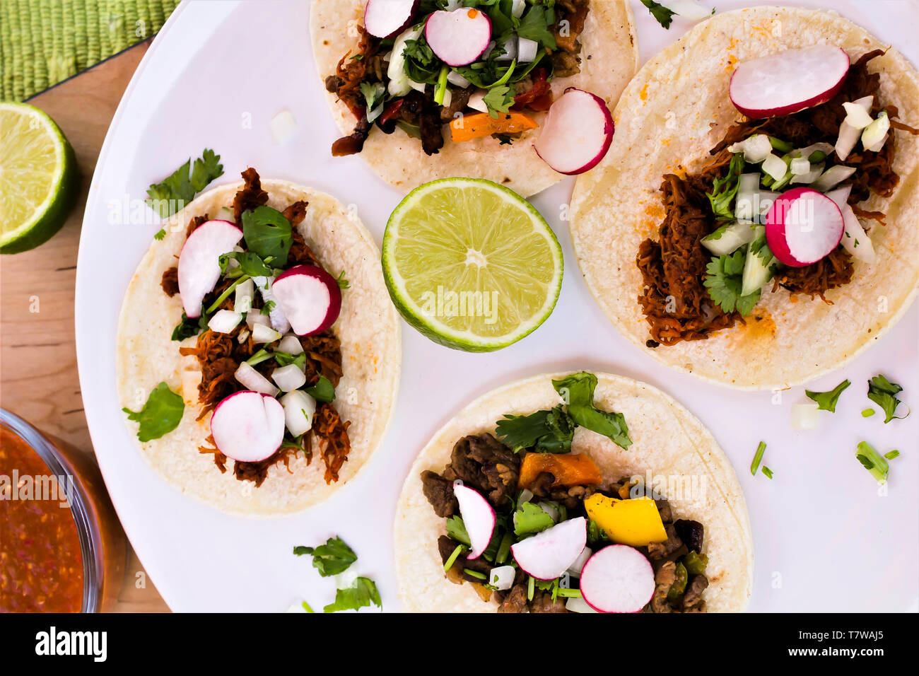 Four open -faced tacos on white plate Stock Photo