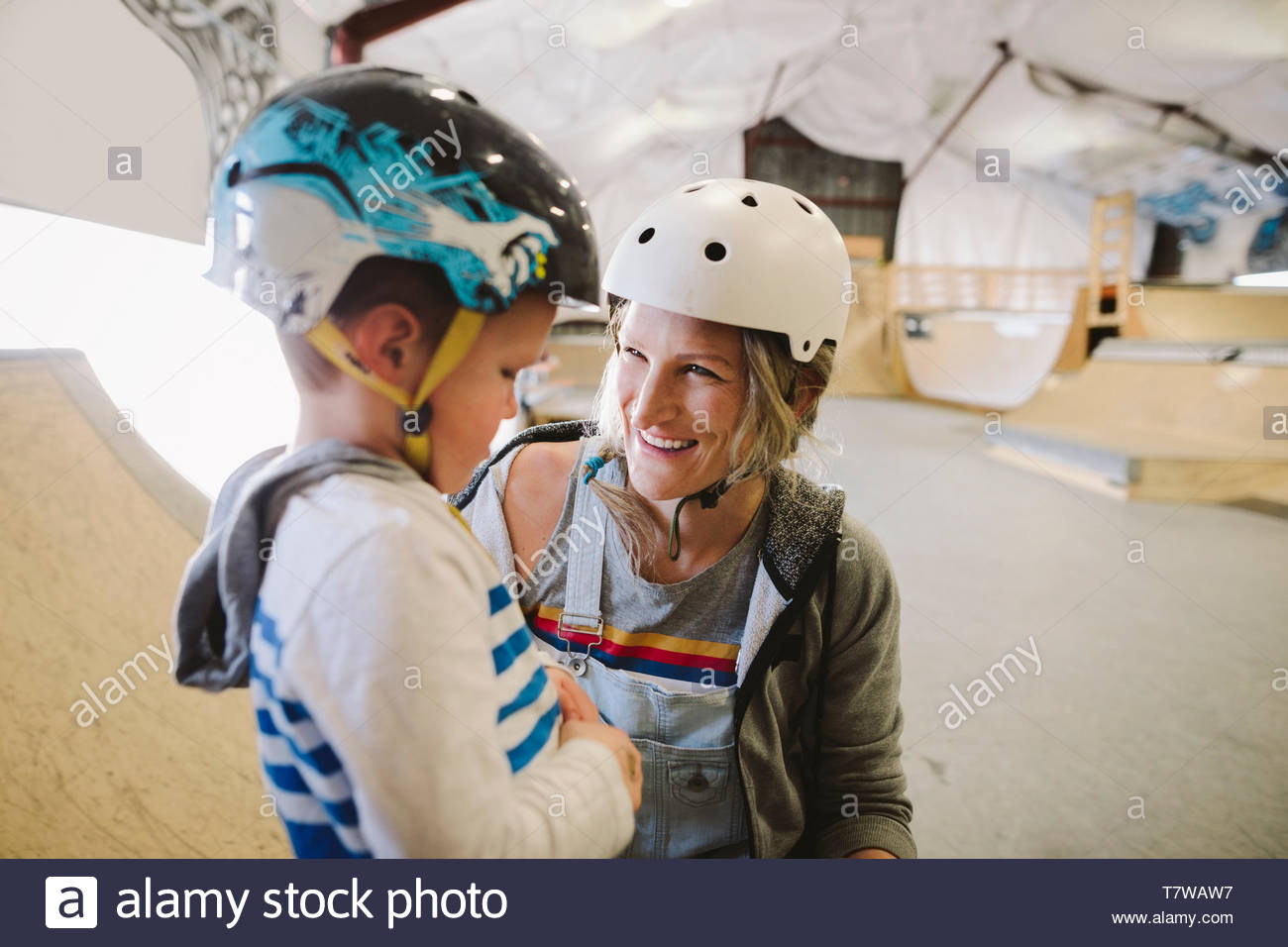 Happy mother and son skateboarding at indoor skate park Stock Photo Alamy