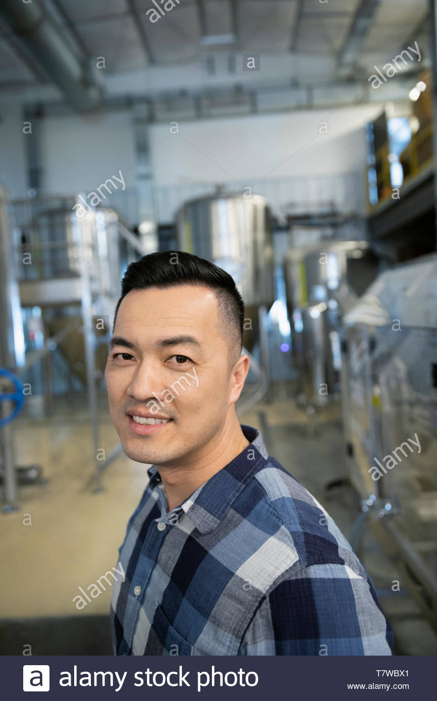 Portrait confident male brewer working in distillery Stock Photo