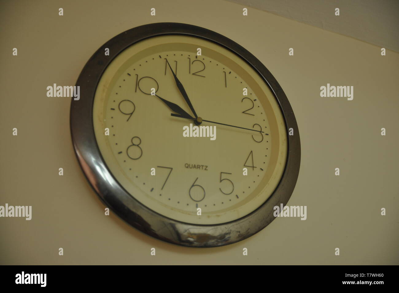 A round clock hangs on the wall Stock Photo
