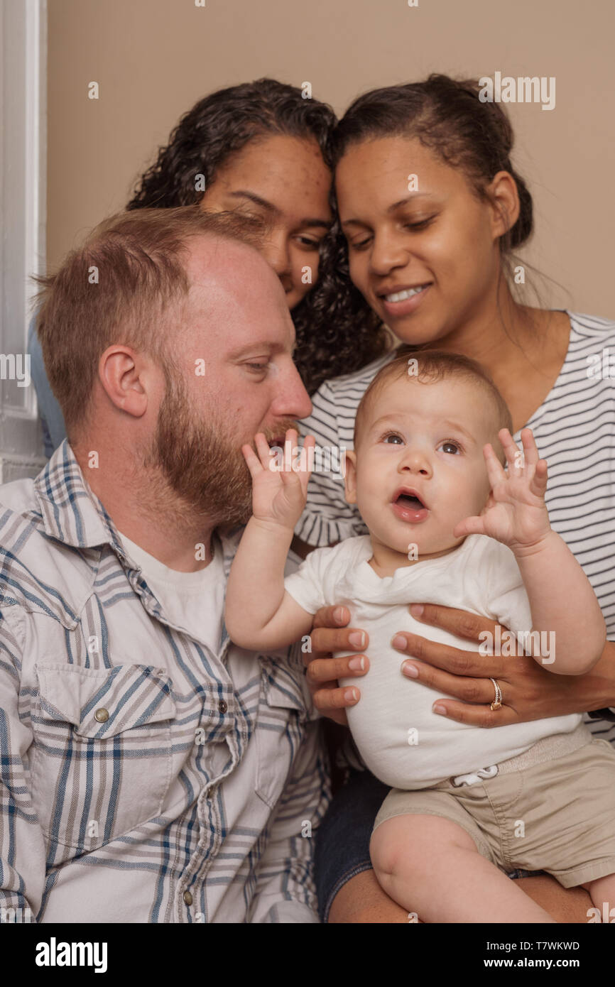 family of  4 in their home north Philadelphia, 6 month old baby, 15 year old sister and parents Stock Photo