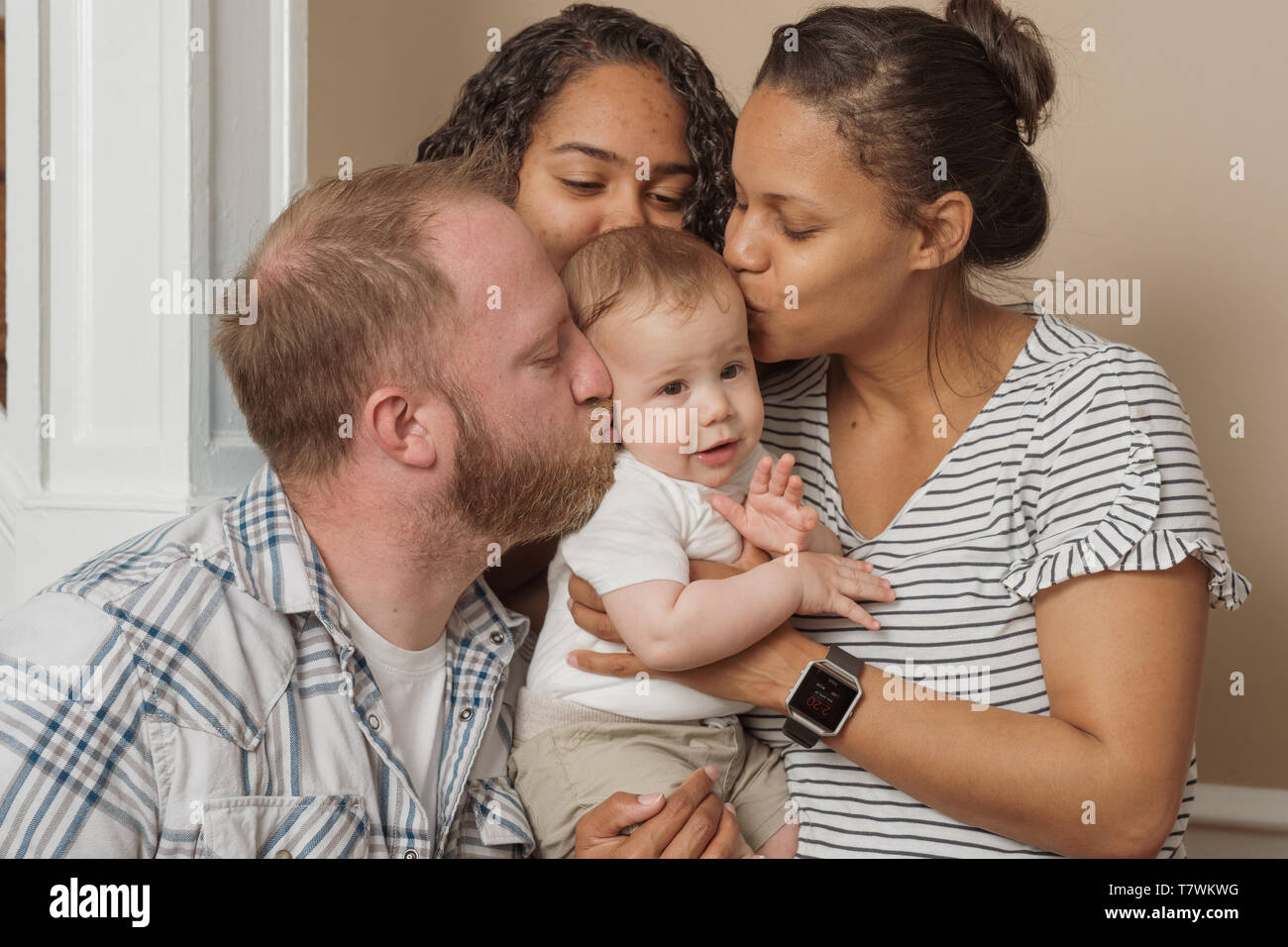 family of  4 in their home north Philadelphia, 6 month old baby, 15 year old sister and parents Stock Photo