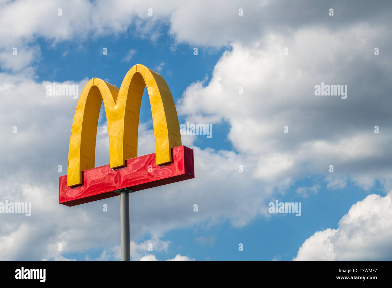 McDonalds sign isolated against cloudy blue sky Stock Photo