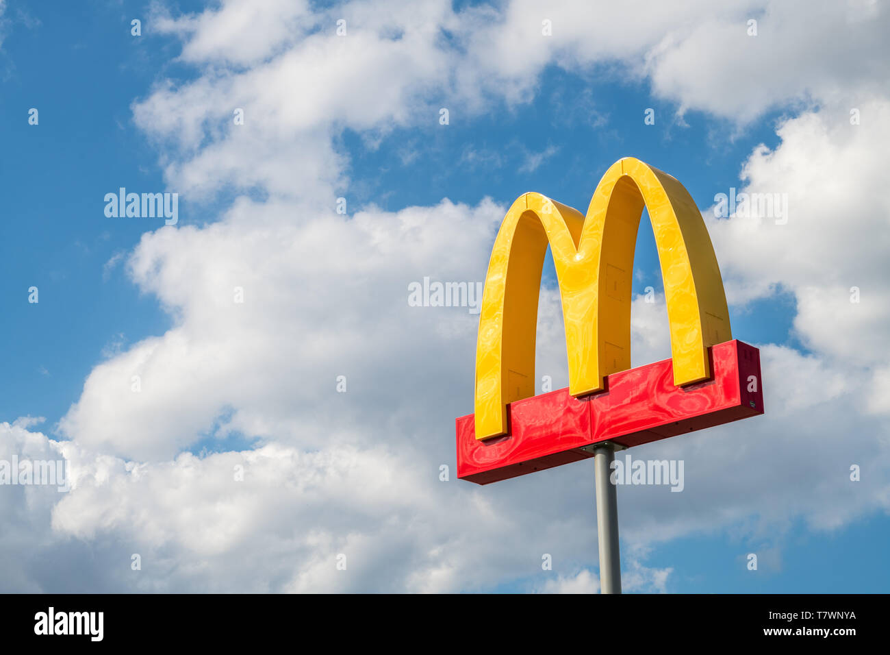 McDonalds sign isolated against cloudy blue sky Stock Photo