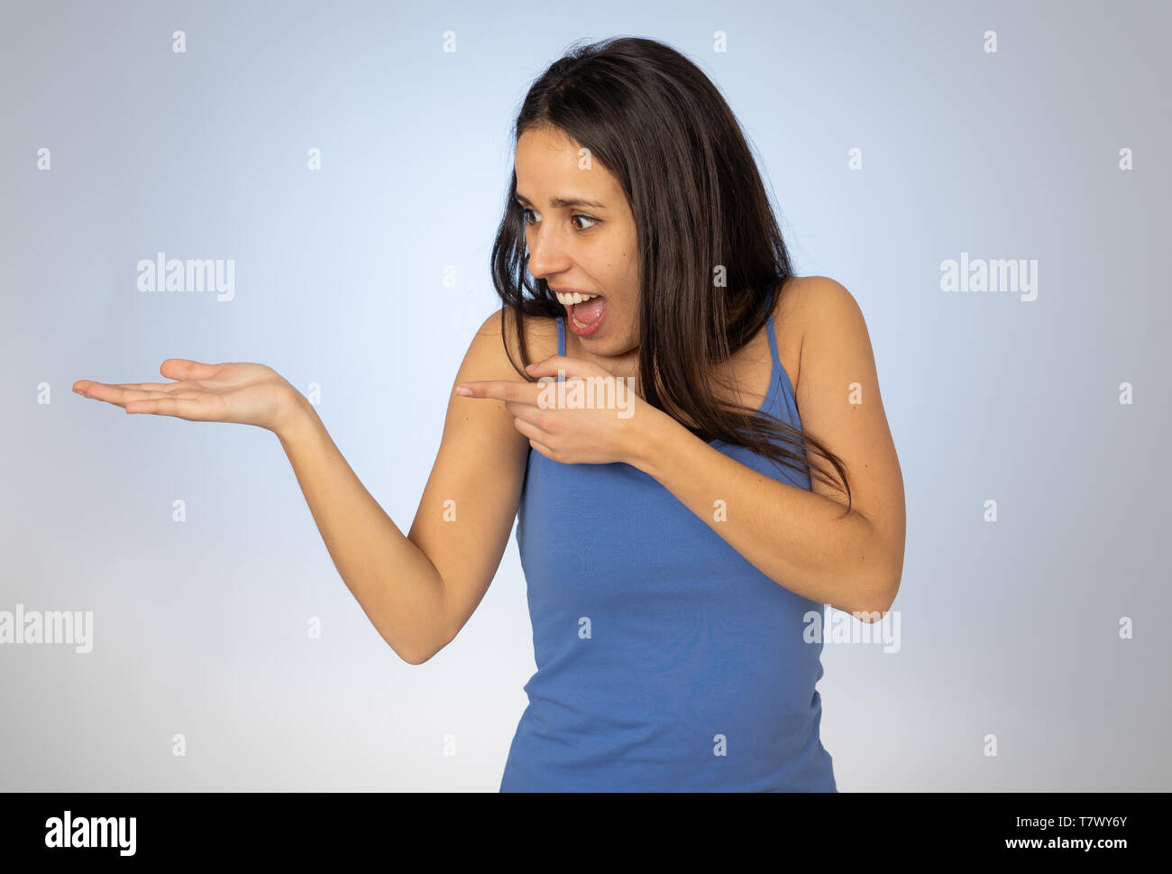 Portrait of happy young woman showing empty copy space on open hand ...