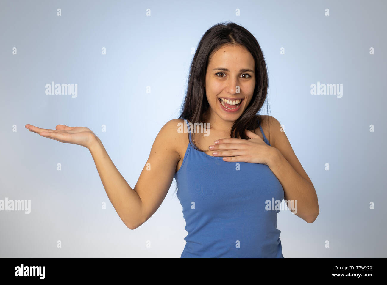 Portrait of happy young woman showing empty copy space on open hand ...