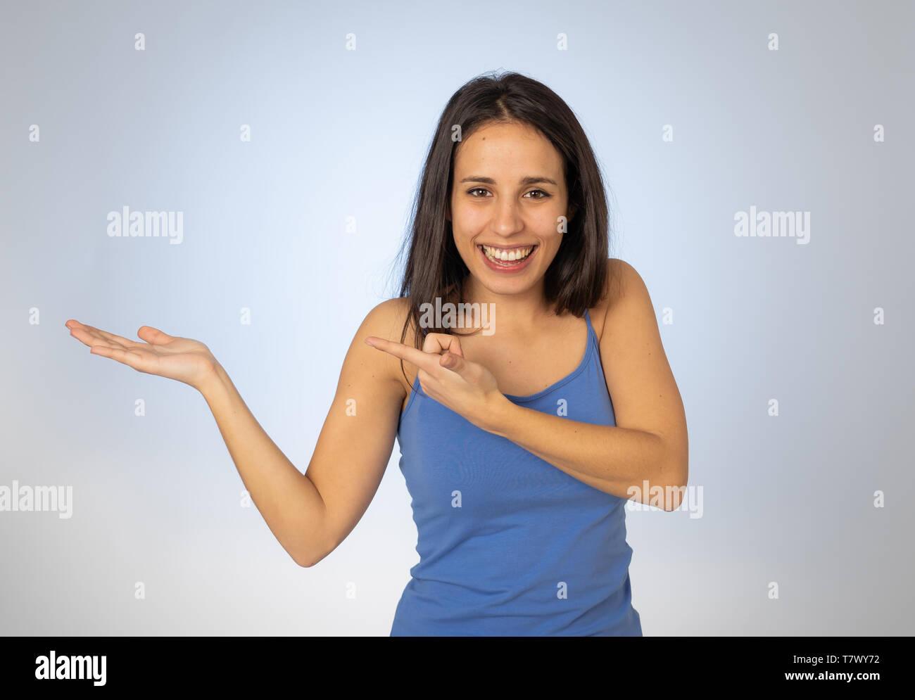 Portrait of happy young woman showing empty copy space on open hand ...