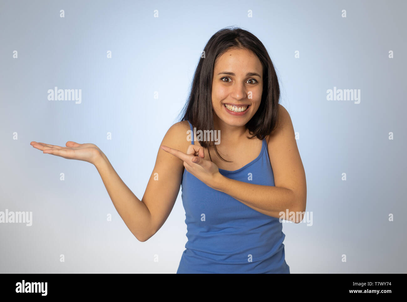 Portrait of happy young woman showing empty copy space on open hand ...
