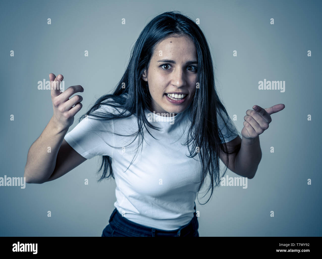 Close up of young attractive frustrated latin woman in stress with furious face. Looking mad and disappointed making angry gestures. In neutral backgr Stock Photo