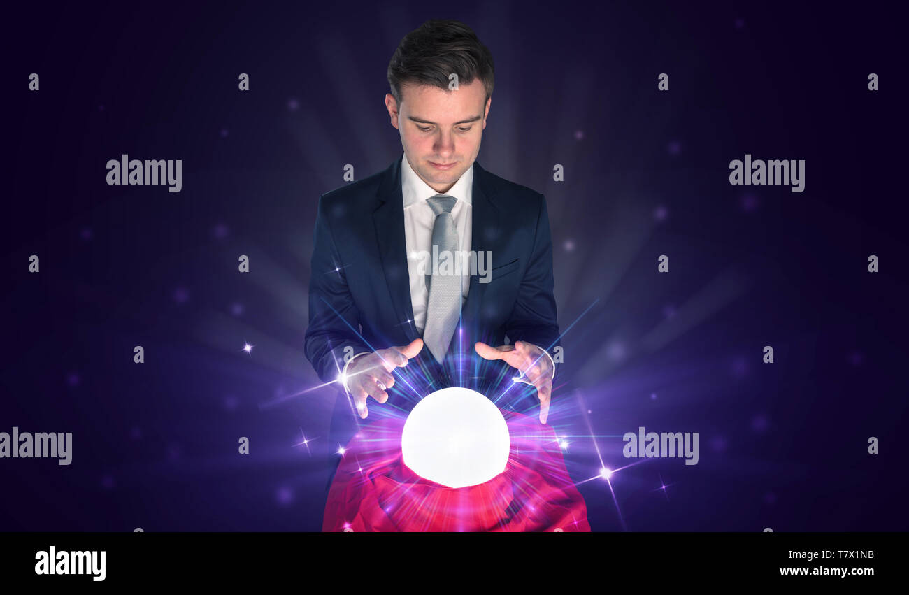 Young businessman sitting with crystal ball in action Stock Photo - Alamy