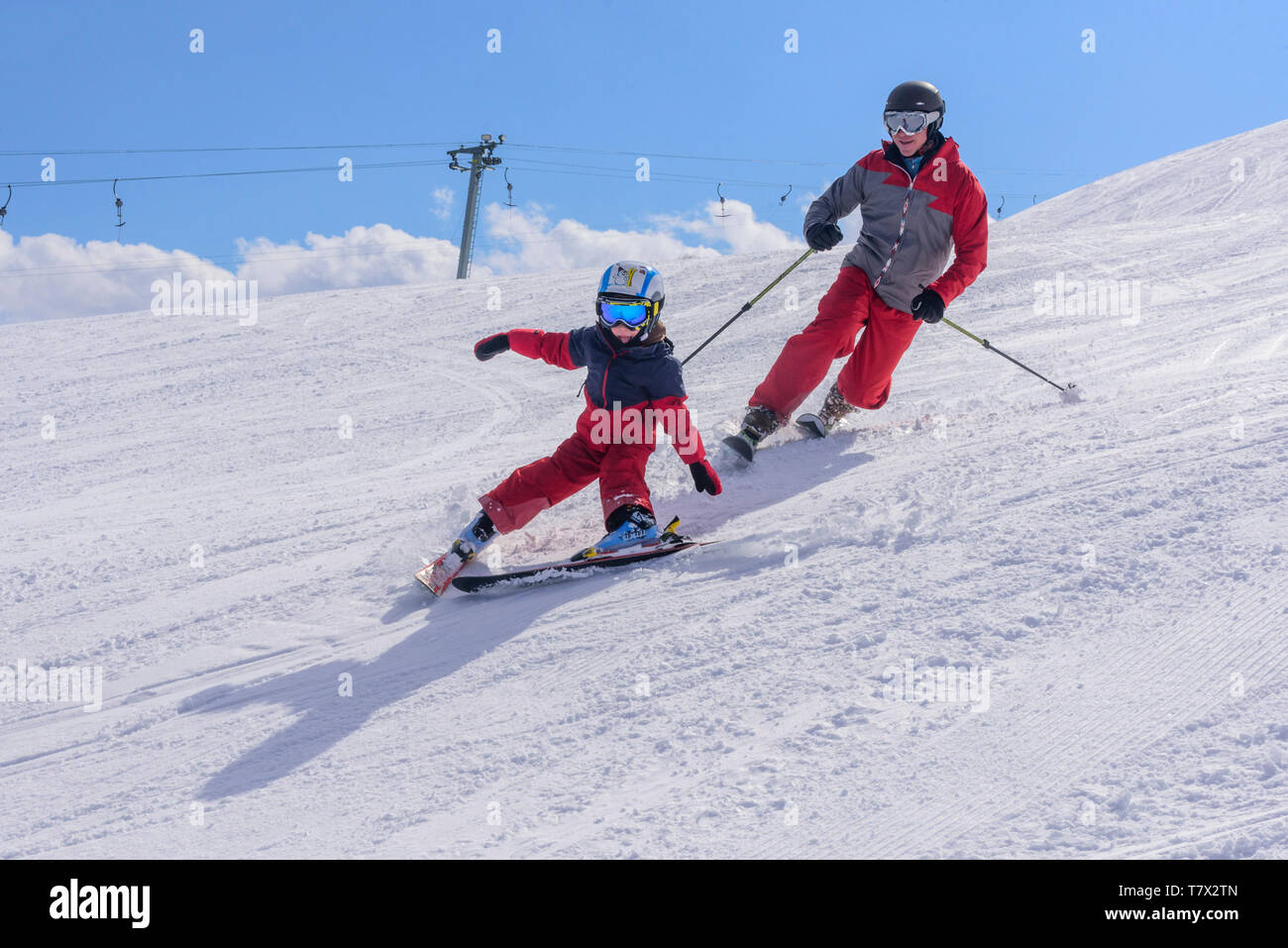 Young boy skiing with his father on good prepared slope Stock Photo