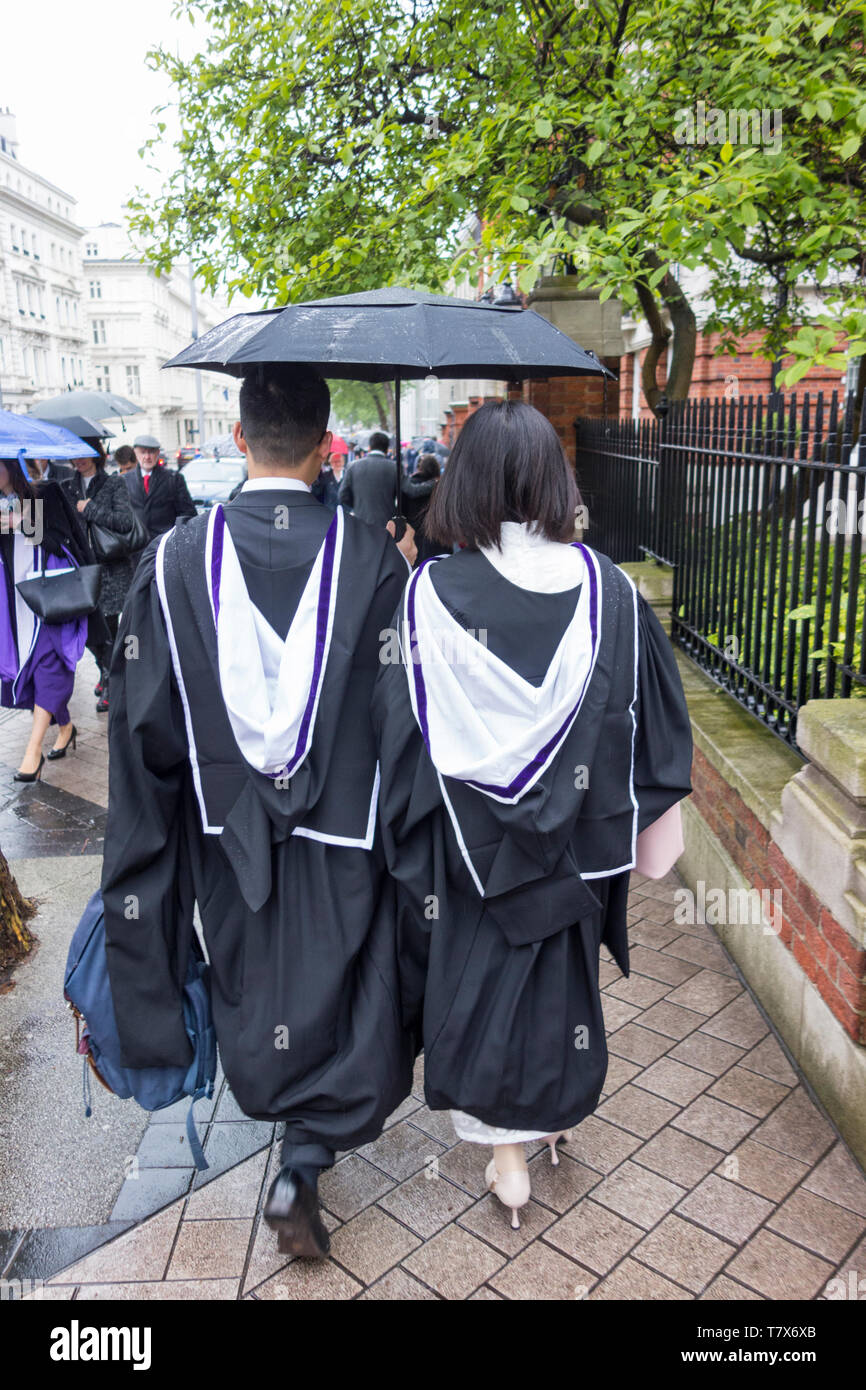A gowned couple walking down Exhibition Road after the Imperial College Postgraduate Graduation ceremonies Stock Photo