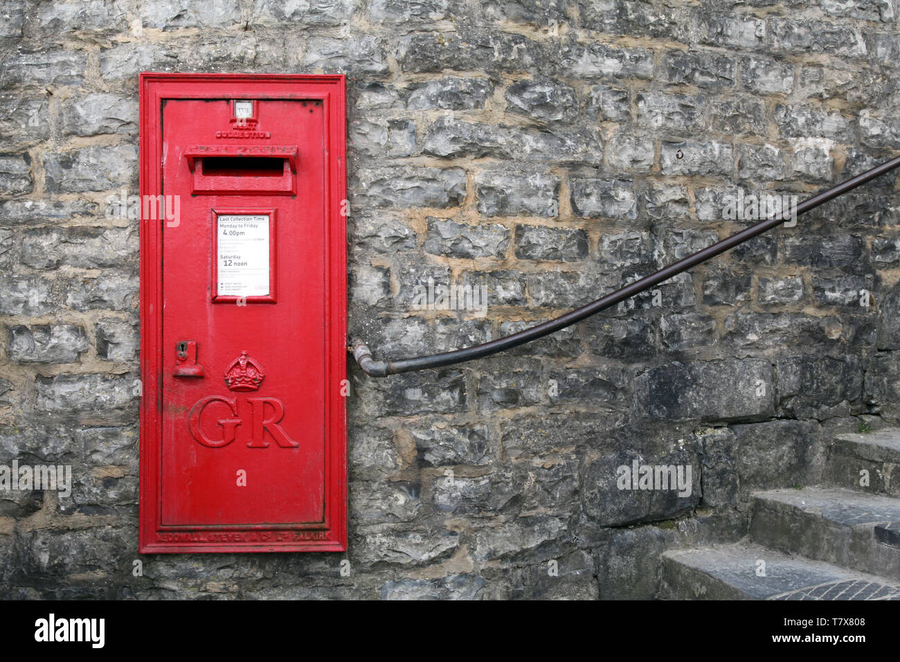 Lyme Regis, Dorset, UK - Classic Red George VI postbox mounted against brick wall with copy space Stock Photo