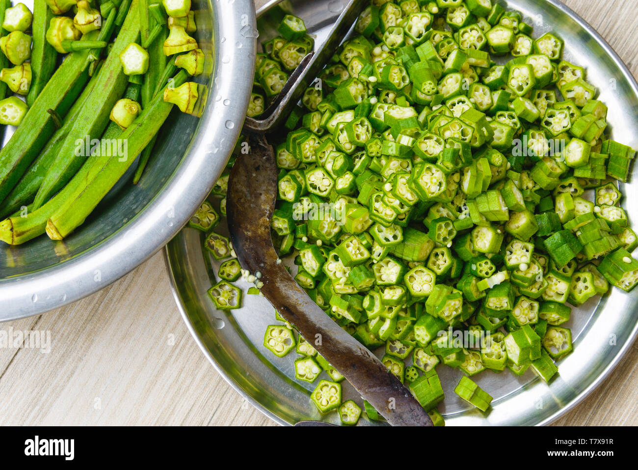 Overhead shot of okras and cut okras. A traditional nepalese knifein the plate. Stock Photo