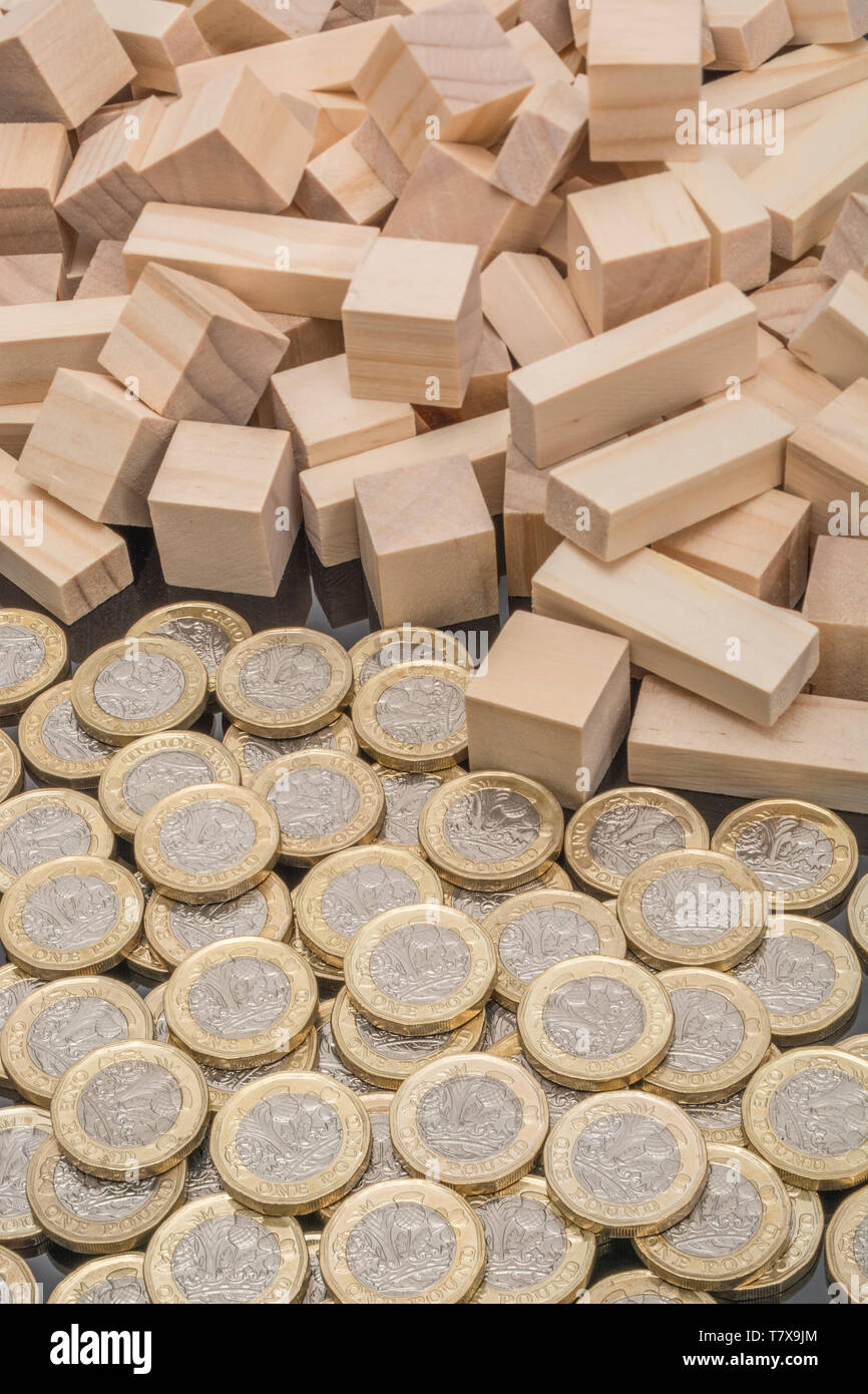 New pound coins + jumbled / tumbled wooden bricks & blocks. Sterling pound crash, drop in £, pound sell-off interest rate collapse, market crash 2020 Stock Photo