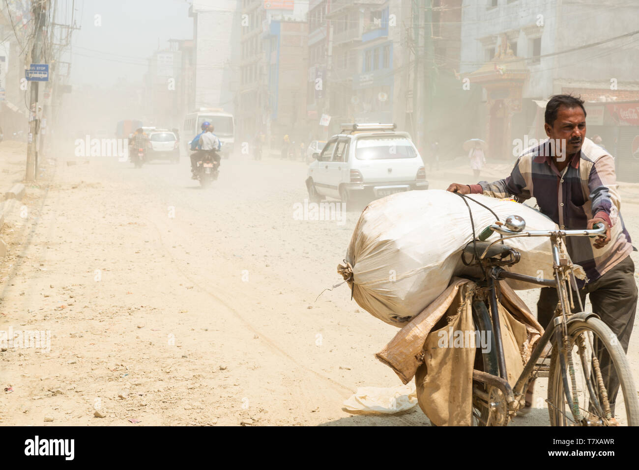 KATHMANDU, NEPAL - 9 MAY, 2019: Traffic on Boudha Road put dust in the air as the road is not blacktopped. It is on ongoing issue for the area's resid Stock Photo