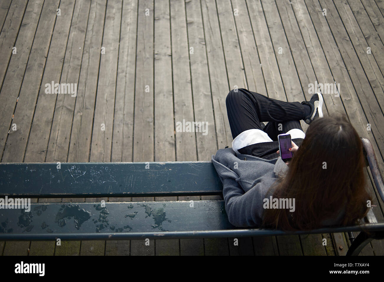 Over the shoulder shot of a teenage girl looking at her mobile phone Stock Photo