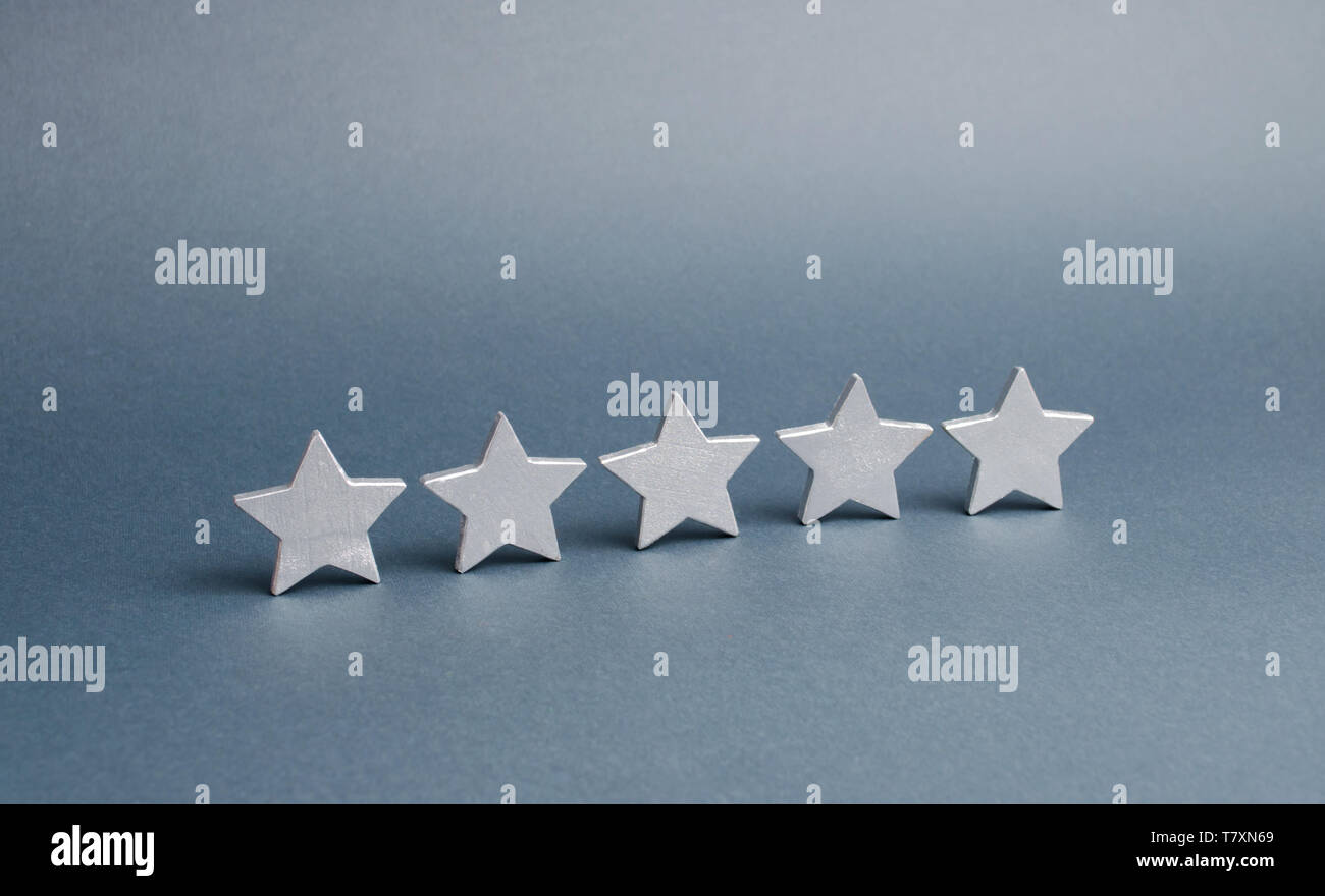 five stars on a gray background. The concept of rating and evaluation. The rating of the hotel, restaurant, mobile application. Quality service, buyer Stock Photo