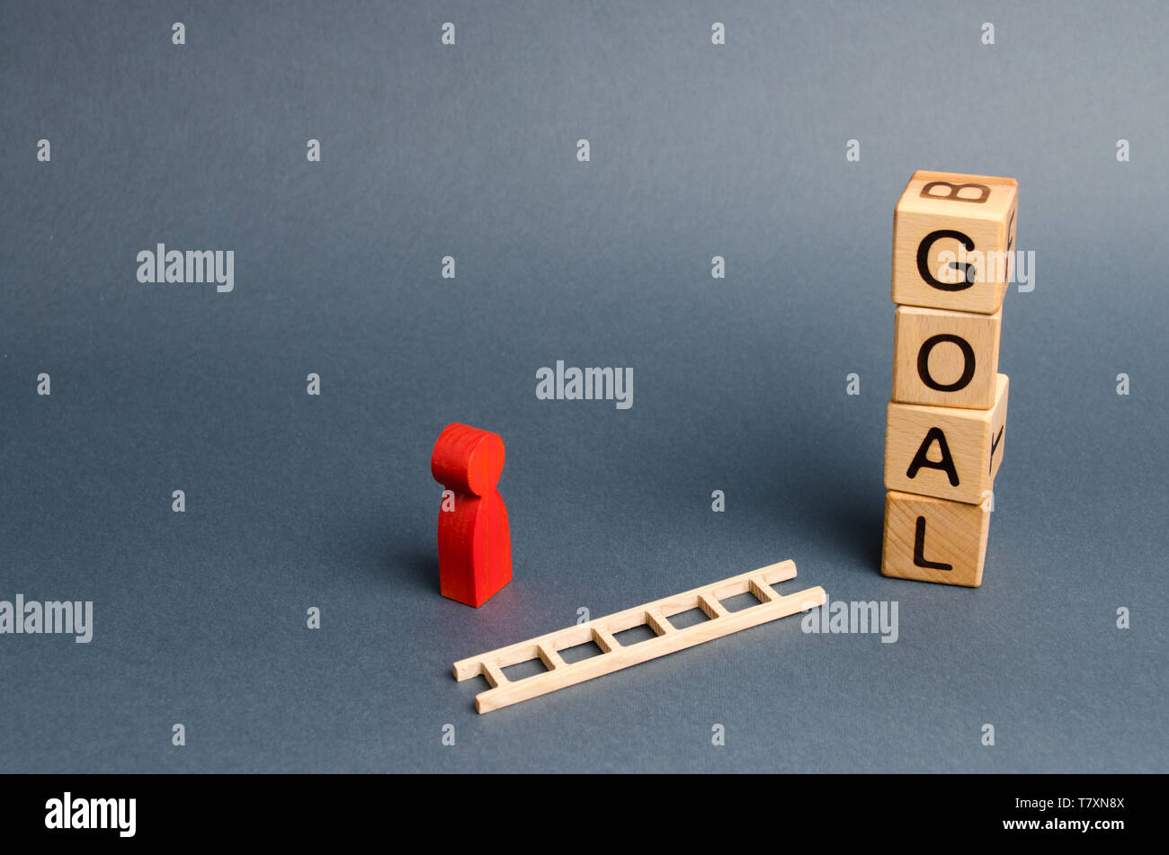tower of cubes with an inscription goal and a red figure of a man stands near fallen ladder. concept of achieving the goal, subject to the application Stock Photo