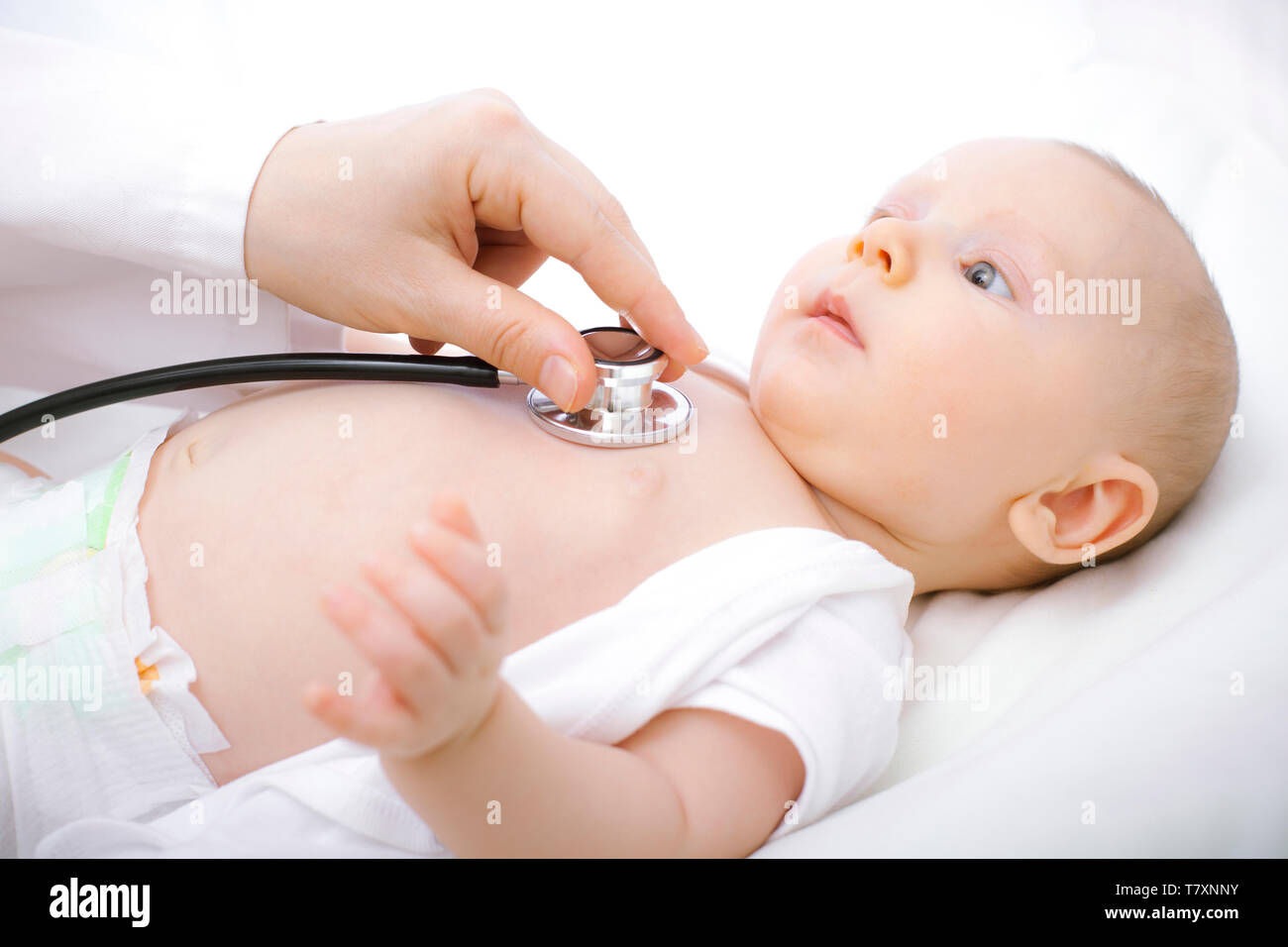 Doctor checks the heartbeat of a newborn with a . Concept of care and health of children. Stock Photo