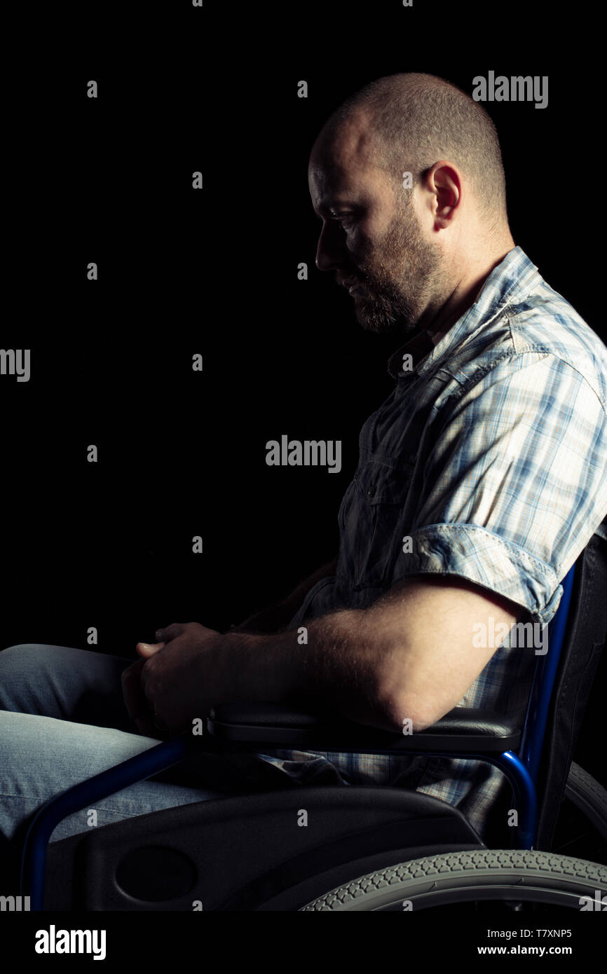 Portrait of a man sitting on a wheelchair for disabled people, sad expression. Stock Photo