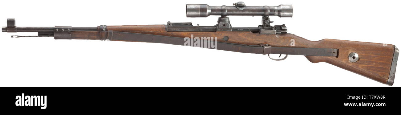 A scope rifle 98 k, Mauser, with high top-hinged mount and scope Dialytan, cal. 8 x 57, no. 42064d. Matching numbers. Mirror-like bore. Code on receiver head covered by front mount base, but various acceptance marks eagle/'135'. According to serial number manufactured after 1944 at Mauser-Werke AG, Oberndorf. Sheet steel-stamped magazine plate. Original finish, partially thin and somewhat spotted. Dark laminated stock without external number, not taken apart. Complete with strapping, pitted cleaning rod and front sight guard. Mounted with high to, Additional-Rights-Clearance-Info-Not-Available Stock Photo