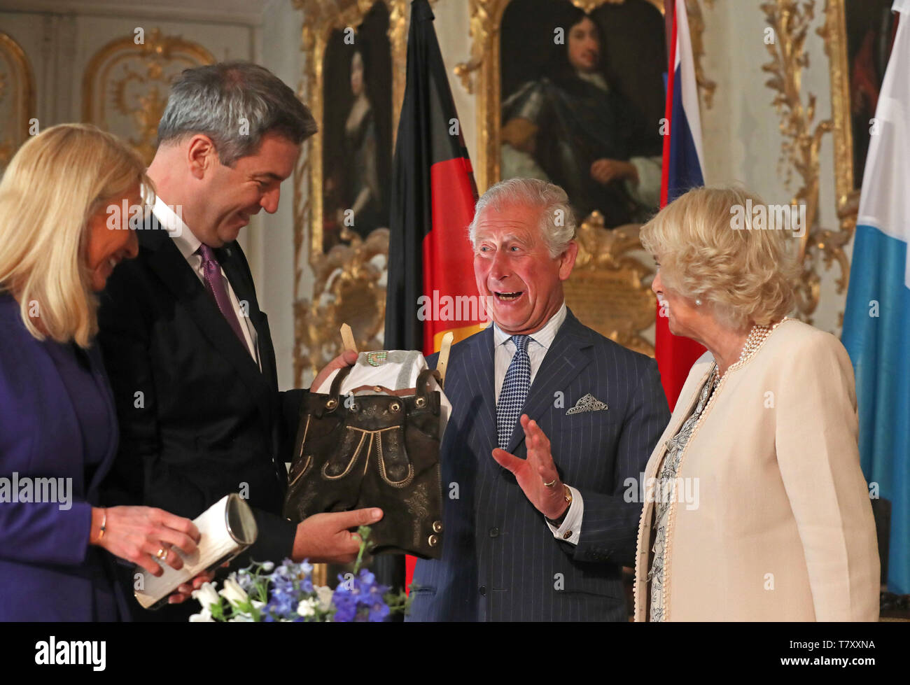 The Prince of Wales and the Duchess of Cornwall are given a pair of baby lederhosen as they are officially welcomed to Munich, Germany, in an event hosted by the Minister-President of Bavaria Markus Soder. Stock Photo