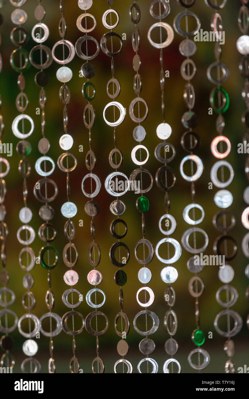 A curtain of round shiny metal circles in warm atmosphere. Stock Photo