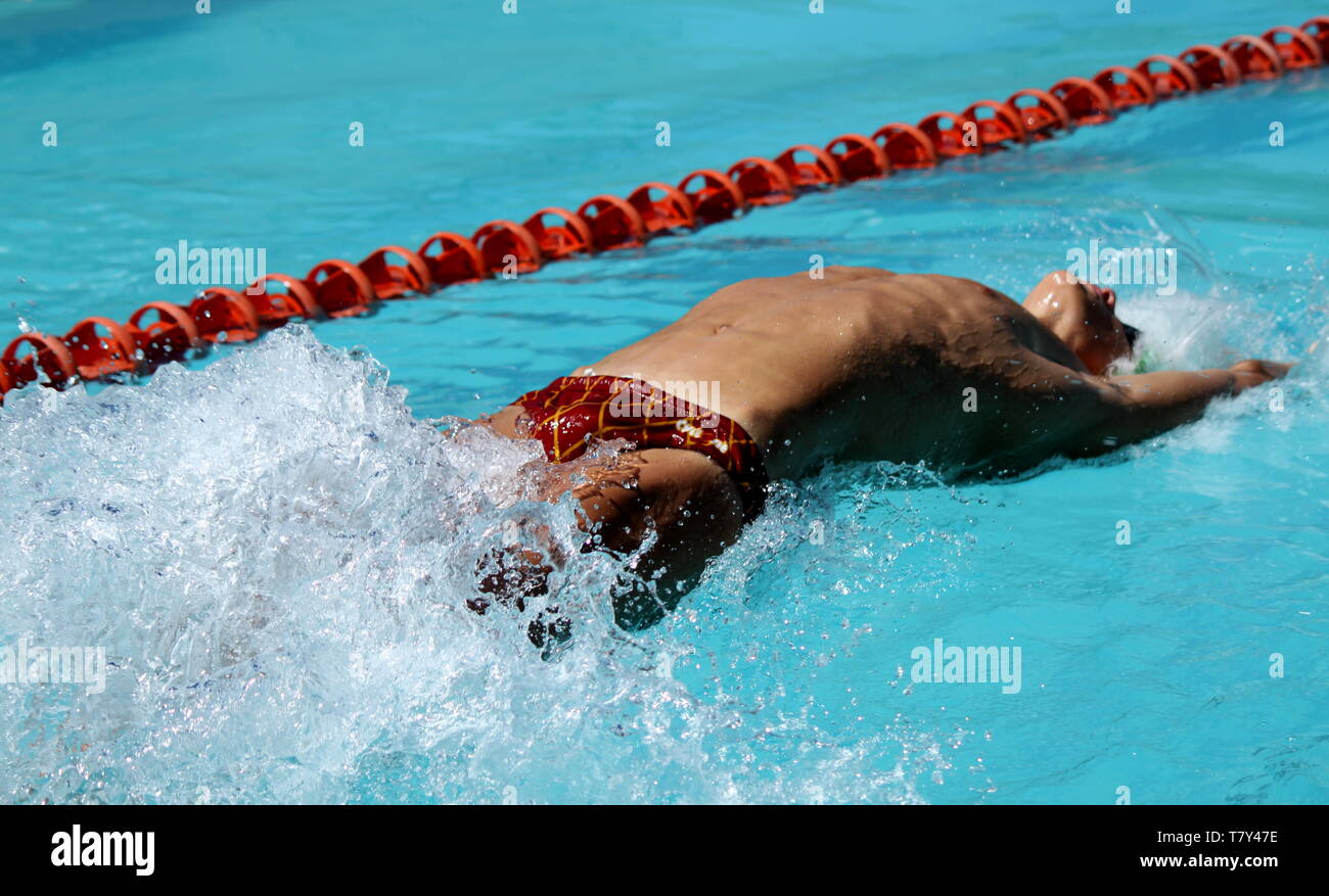 Young guy swimming the back stroke in a gala Stock Photo