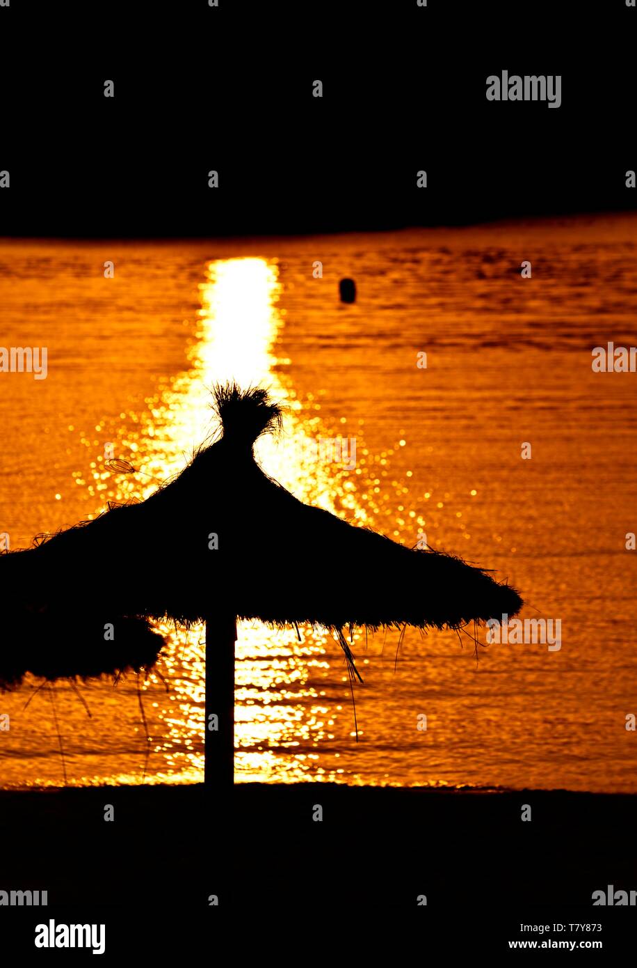 Beach parasol silhouette,orange sunset,sea,ocean,Menorca,Minorca,Balearic Islands Spain, Stock Photo