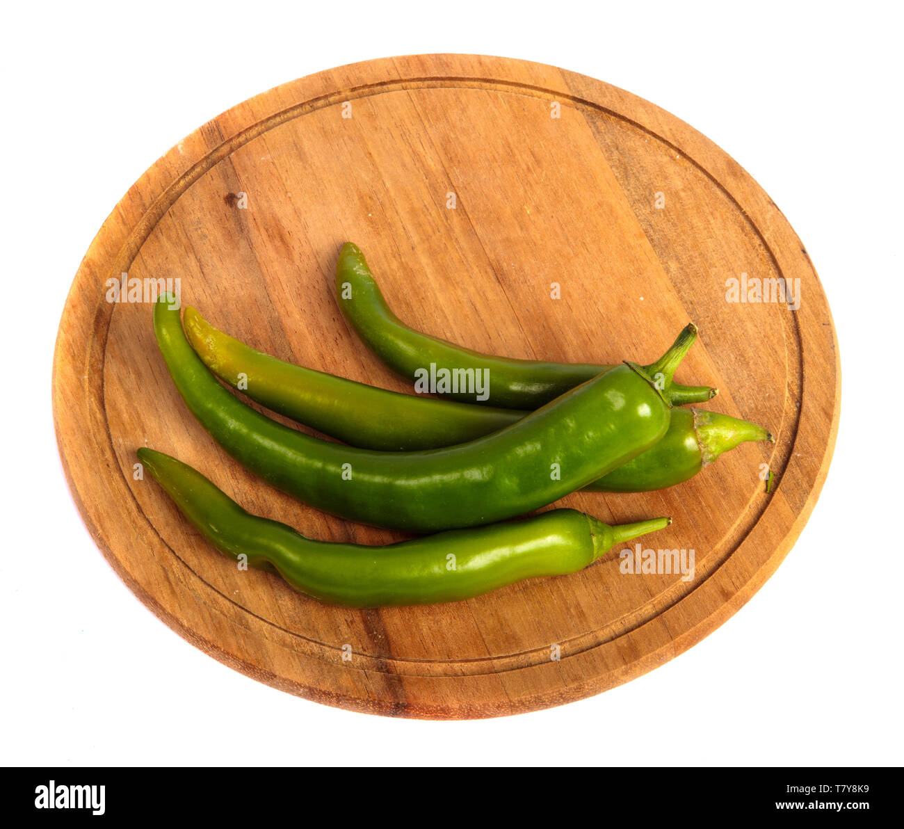Green chilli peppers on a wooden cutting board. on a white Stock Photo ...