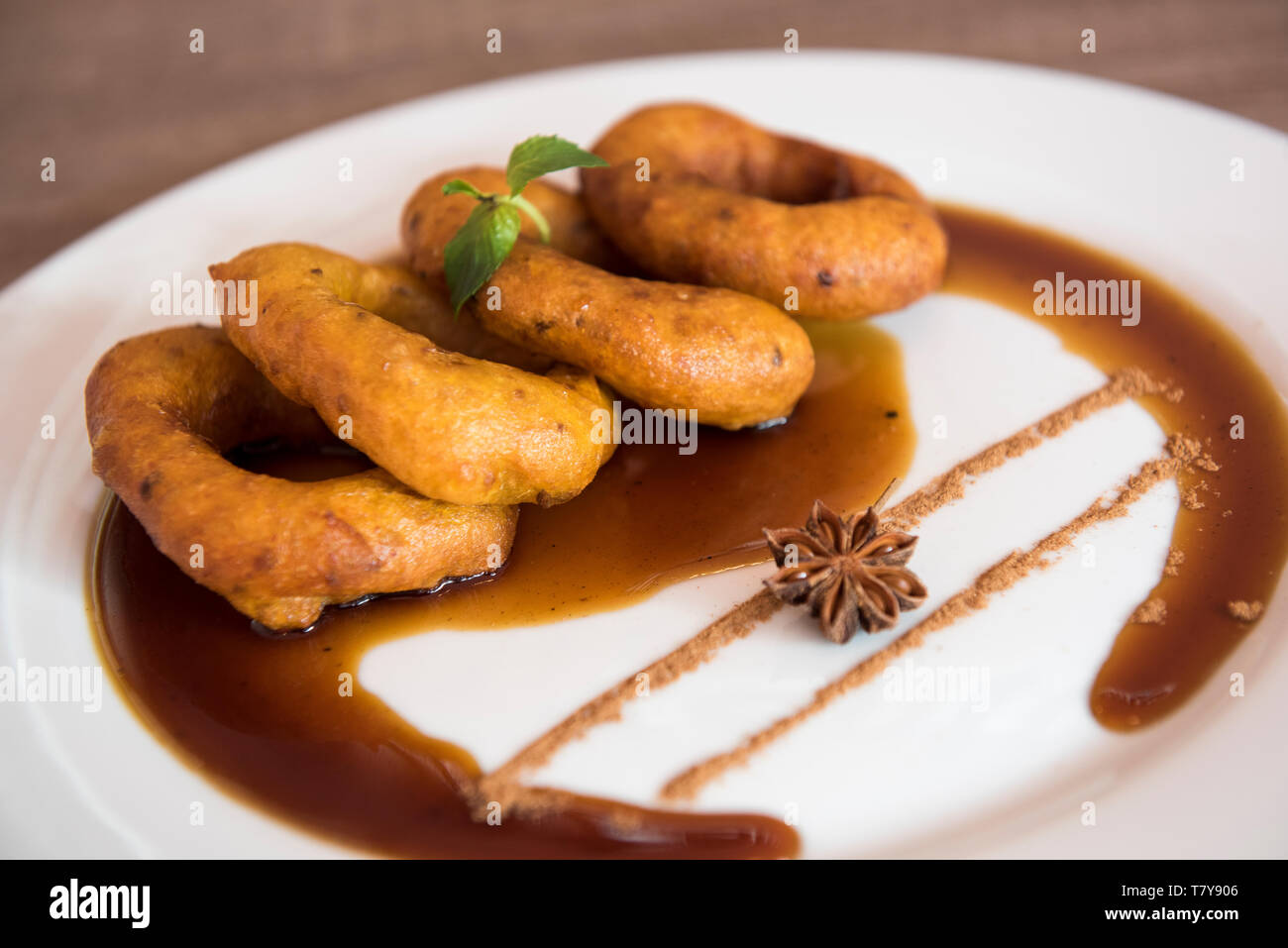Traditional peruvian dessert Picarones. Made of sweet potato, pumpkin and wheat flour. Fried an served whit honey figs. Stock Photo