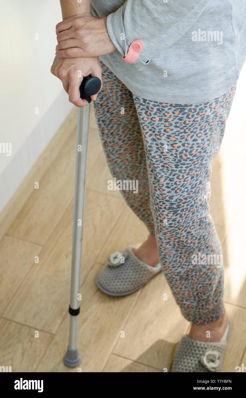 Senior woman standing with her hands on the handles of a walking cane. Rehabilitation and