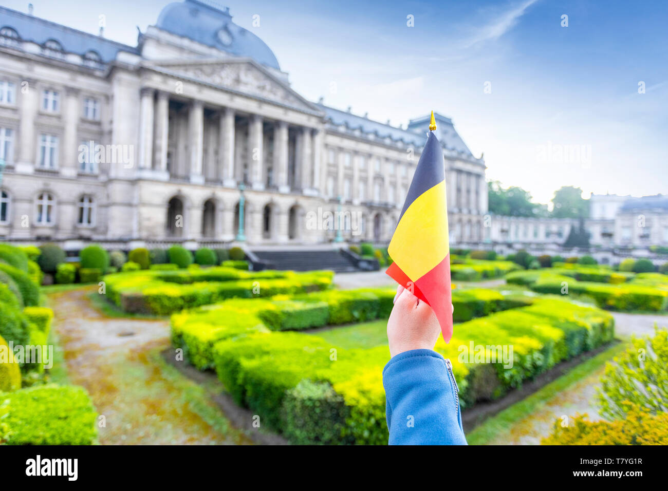 Royal Palace of Brussels and flag of Belgium in female hand, Belgium Stock Photo