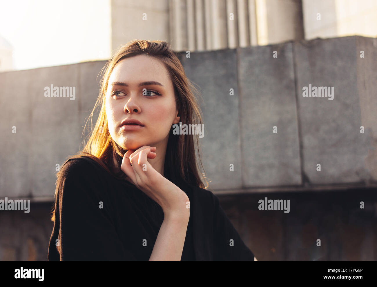 Close up portrait of beautiful long hair girl fashion model on sunset at city street Stock Photo