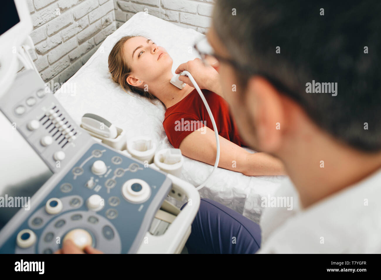 Female patient getting thyroid ultrasound exam in hospital Stock Photo