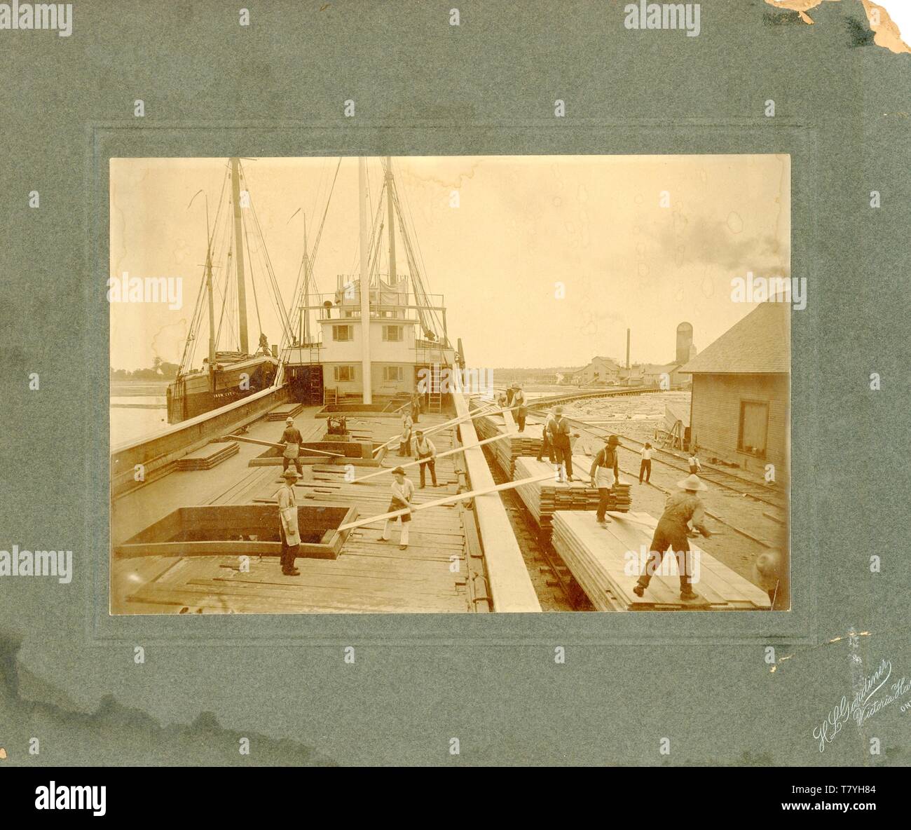 Loading lumber on a ship, ca. 1890.  MP AP Stock Photo
