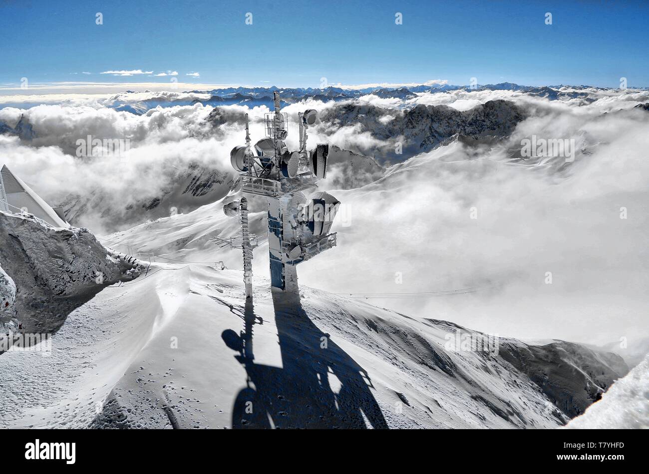 Mast mit Richtfunk- und Mobilfunkantennen. Im Hintergrund das winterlich verschneite Alpenpanorama Stock Photo