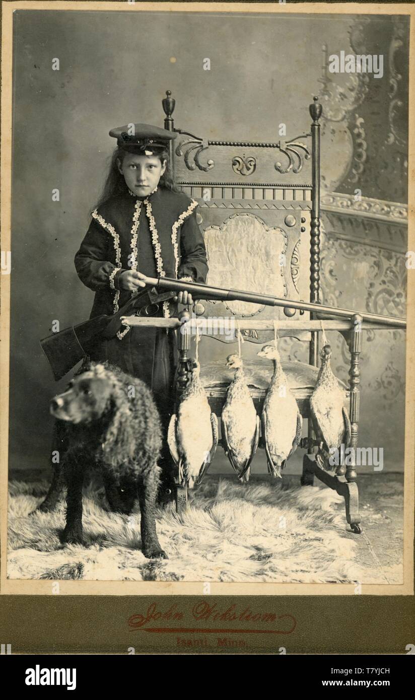 Young woman putting a shell into a shotgun, a hunting dog, ducks, ca. 1890.  Ptgr:  John Wikstrom, Isanti, MI.  MP AP Stock Photo