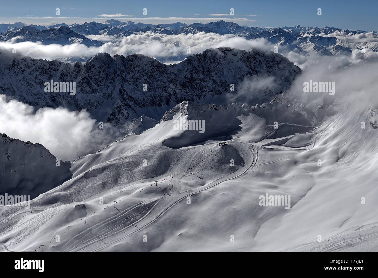 Vor dem winterlichen Alpenpanorama ist der Sessellift Sonnenkar und die Talstation zu erkennen. Der Schnee ist fast unberührt Stock Photo